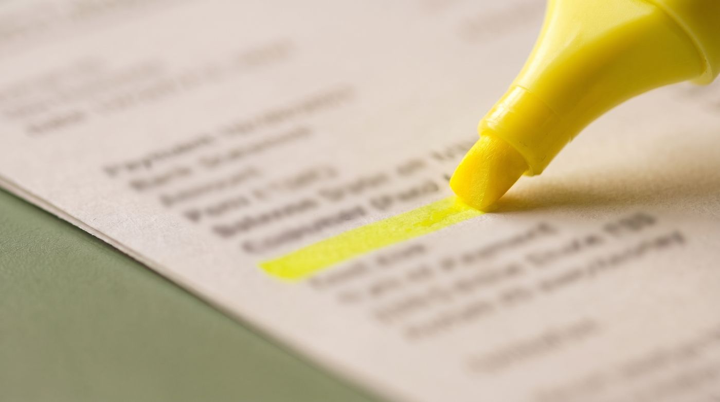 A yellow highlighter marking one line of a printed bank statement.